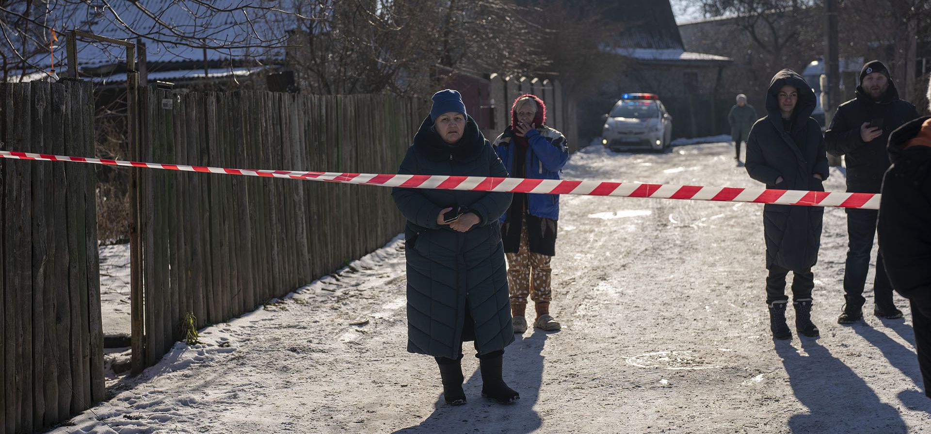 Residentes esperan detrás del cordón policial para regresar a sus hogares después de un ataque con cohetes en los suburbios de Kyiv, Ucrania, el viernes 10 de febrero de 2023. (Foto AP/Emilio Morenatti)