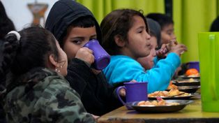 En el comedor de la Escuela ARA General Belgrano los chicos reciben la copa de leche y la ración de almuerzo.