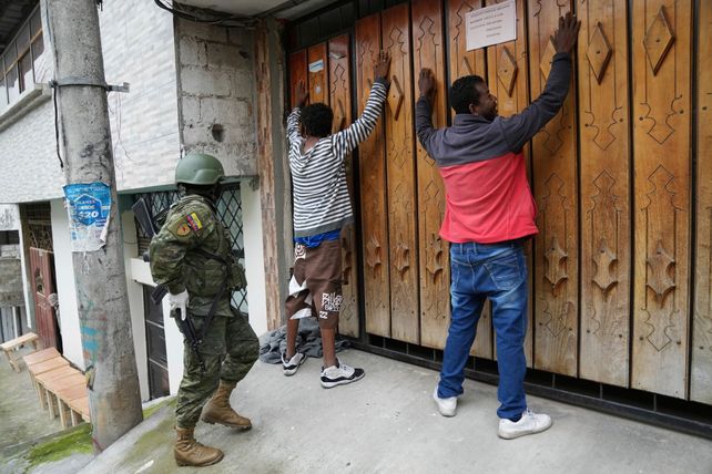 Un militar procede a registrar a dos hombres durante una patrulla por el sur de Quito