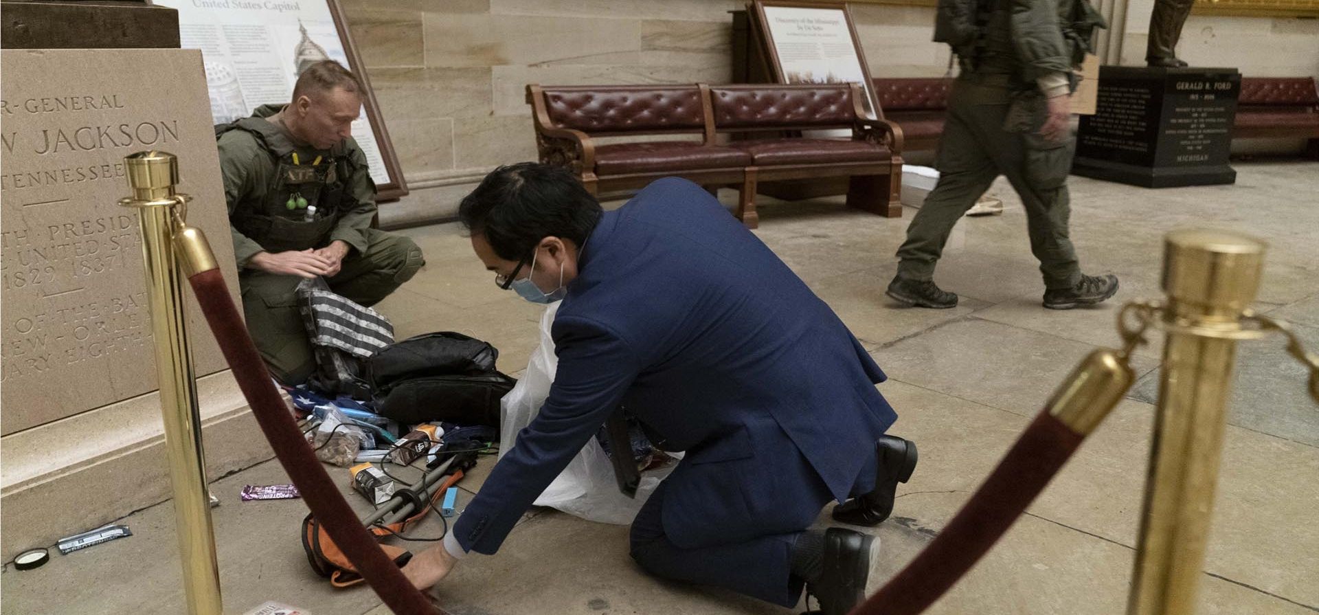 Andy Kim, demócrata de Nueva Jersey, limpia los escombros y las pertenencias personales esparcidas por el piso de la Rotonda en las primeras horas de la mañana del 7 de enero de 2021, después de que los manifestantes pro Trump irrumpieran en el Capitolio en Washington. 