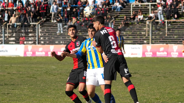 Boretto rechaza de cabeza ante Segovia. Newell's ganó por 1 a 0 en la cancha de Argentino.