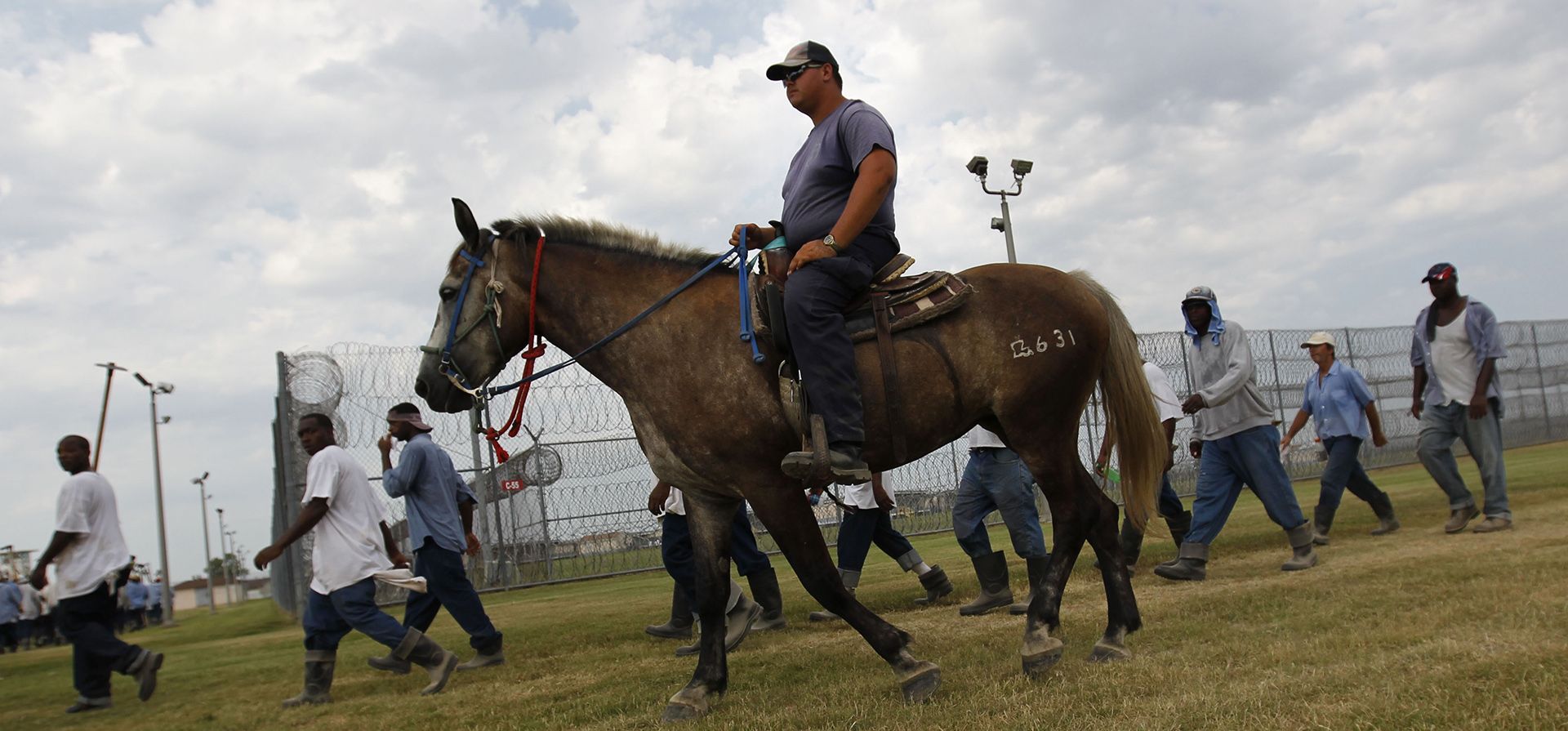 Un guardia de prisión monta un caballo junto a los prisioneros cuando regresan de trabajar en el campo, en la Penitenciaría Estatal de Luisiana en Angola, Luisiana. Casi todas las cárceles estatales y federales para adultos del país tienen algún tipo de programa de trabajo, empleando alrededor de 800.000 personas, según un informe de 2022 de la Unión Estadounidense de Libertades Civiles. (Foto AP/Gerald Herbert) Un guardia de prisión monta un caballo junto a los prisioneros cuando regresan de trabajar en el campo, en la Penitenciaría Estatal de Luisiana en Angola, Luisiana. Casi todas las cárceles estatales y federales para adultos del país tienen algún tipo de programa de trabajo, empleando alrededor de 800.000 personas, según un informe de 2022 de la Unión Estadounidense de Libertades Civiles. (Foto AP/Gerald Herbert)