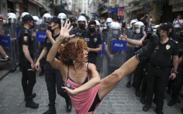 Una manifestante realiza un acto de baile mientras la policía camina para dispersar una manifestación del orgullo en el centro de Estambul.