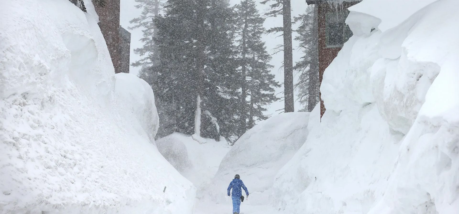 Una persona camina entre bancos de nieve que cubren condominios en las montañas de Sierra Nevada después de otra tormenta. Después de años de sequía, el promedio estatal de nieve acumulada para California puede alcanzar un récord. Fotografía: Mario Tama/Getty Images