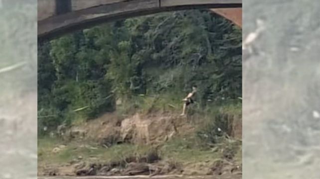 Un joven caminaba sobre una cuerda sobre el río. 