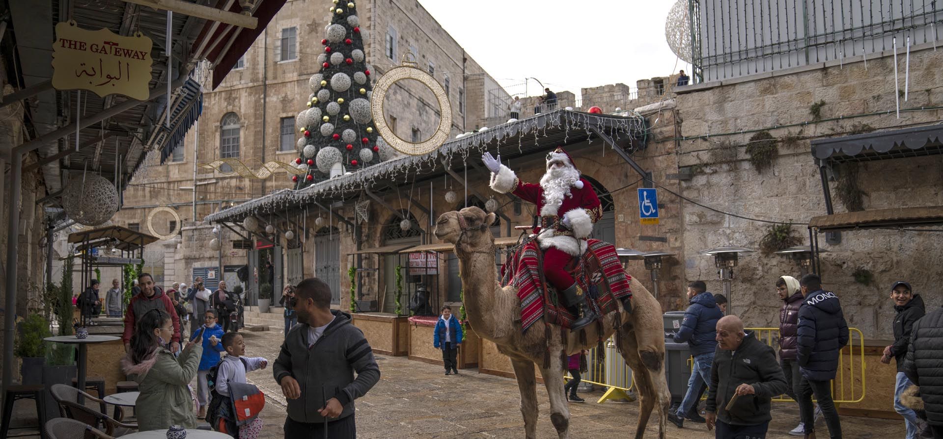 Un hombre vestido como Papá Noel montado en un camello realiza una gira por la Ciudad Vieja de Jerusalén, antes de las próximas vacaciones de Navidad, el jueves 23 de diciembre de 2021. Foto: AP  