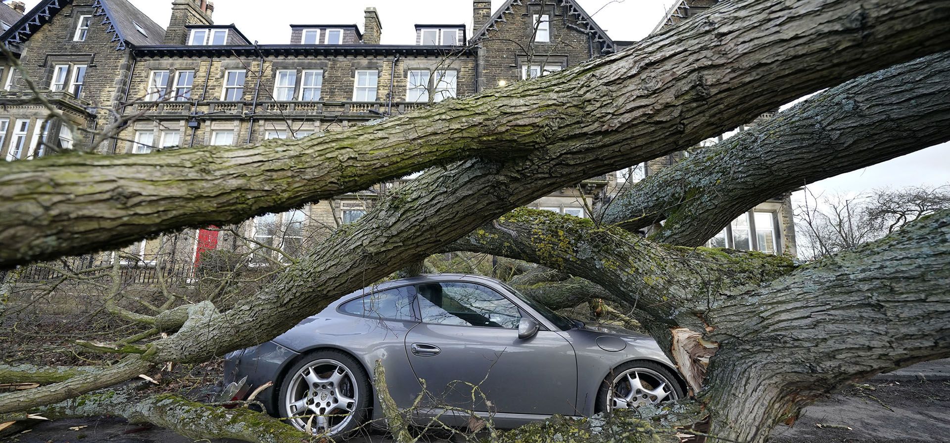 Un automóvil Porsche 911 es dañado por un árbol caído en Harrogate, North Yorkshire, el viernes 17 de febrero de 2023, como resultado de la tormenta Otto. La tormenta, la primera en ser nombrada este invierno, ha sido etiquetada como Otto por el Instituto Meteorológico Danés. (Danny Lawson/PA vía AP)