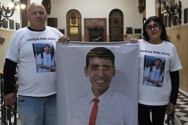 Fabián y Graciela sostienen un banner con la foto que eligieron para reclamar justicia por el crimen de su hijo en barrio Larrea.