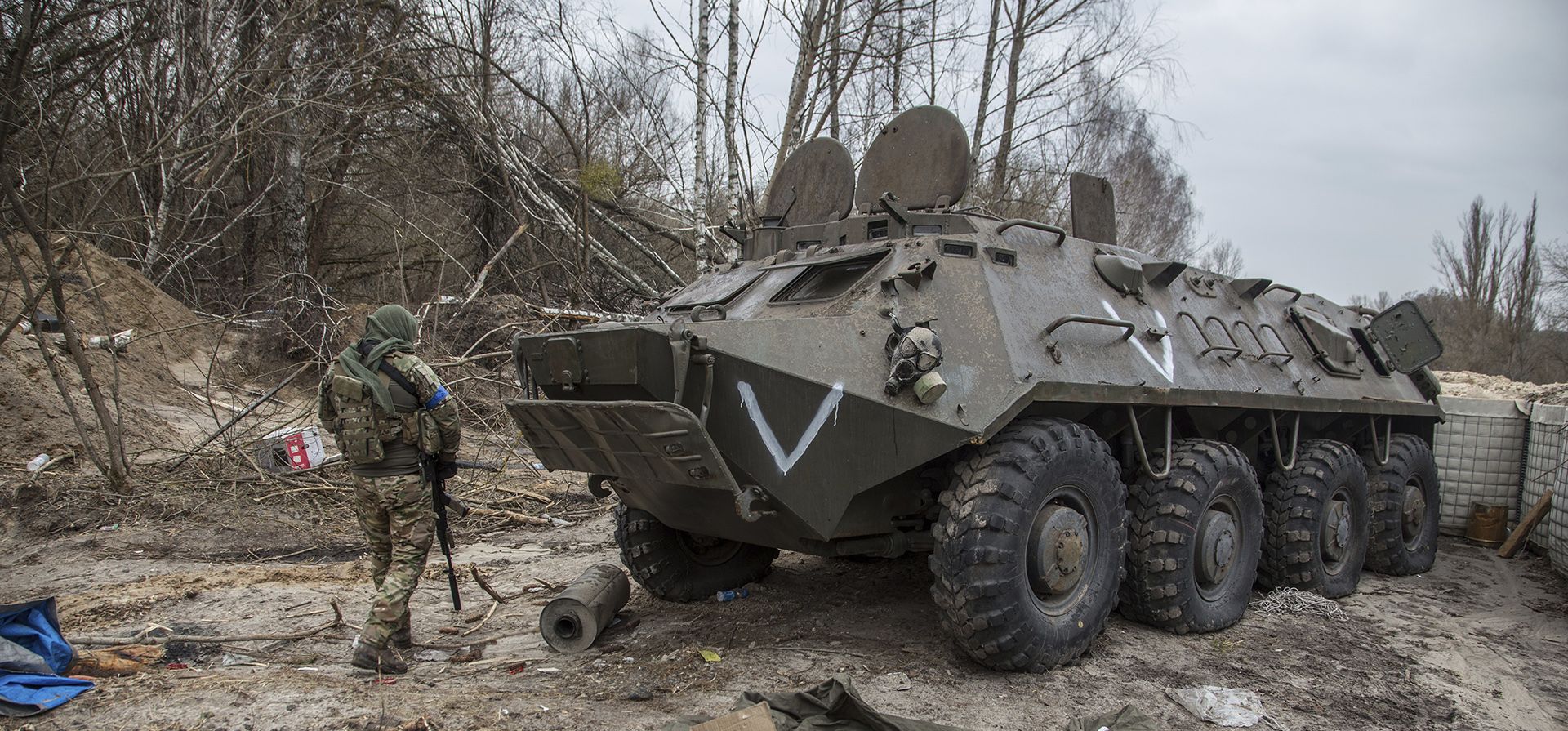 Un militar ucraniano pasa junto a un vehículo militar del ejército ruso abandonado en una carretera cerca de Chernobyl, Ucrania.