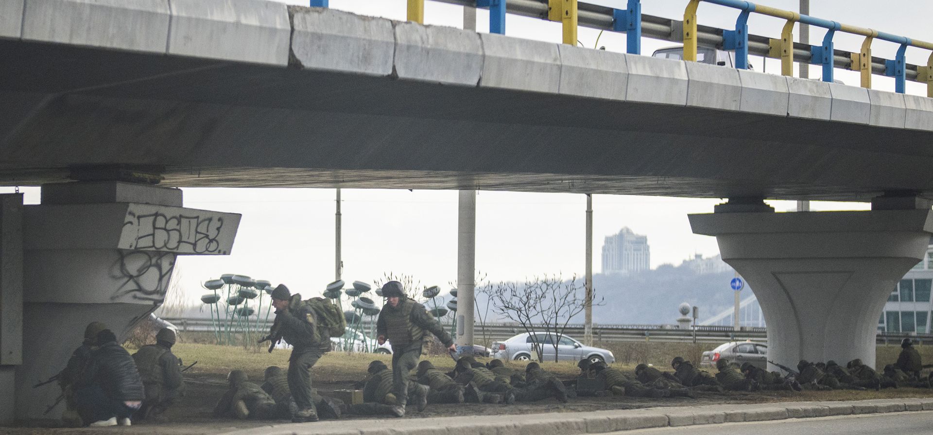 Soldados ucranianos toman posición debajo de un puente durante el cruce de fuego dentro de la ciudad de Kiev, Ucrania, el viernes 25 de febrero de 2022. Rusia presionó su invasión de Ucrania hasta las afueras de la capital el viernes después de desatar ataques aéreos en ciudades y bases militares.