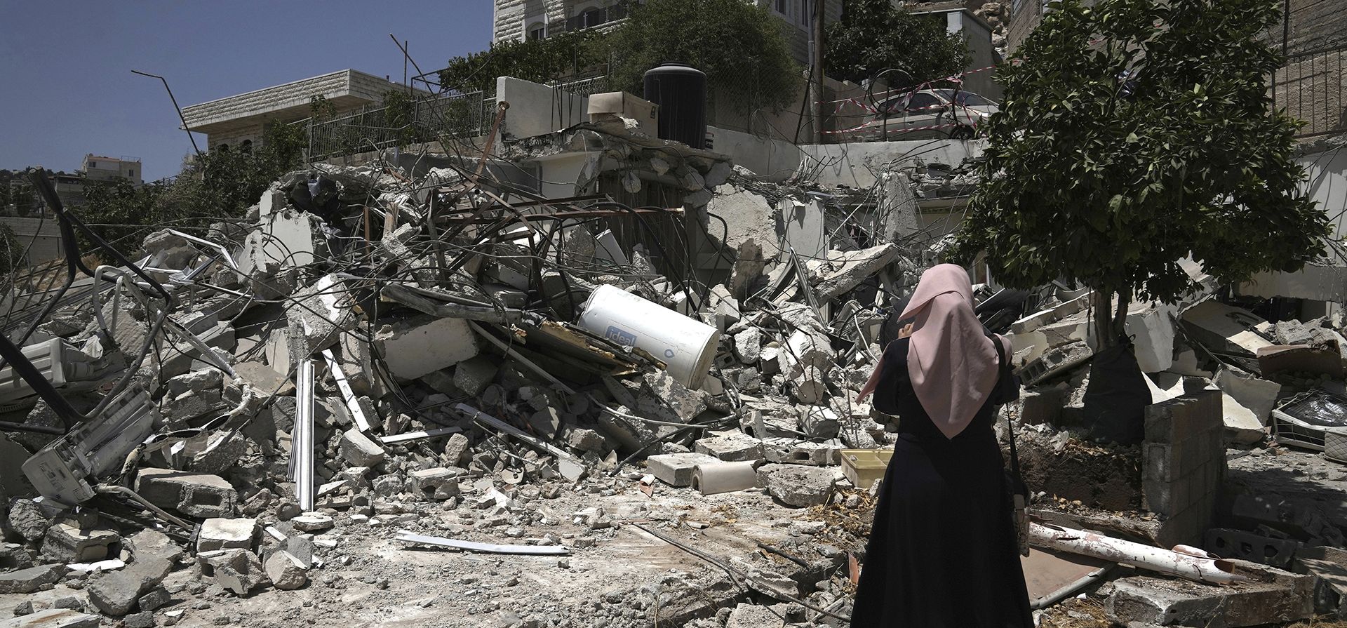 Una mujer palestina filma los restos de la casa demolida de Salah Zghair en el barrio de Silwan, en el este de Jerusalén, el martes 16 de agosto de 2022. Trabajadores del municipio de Jerusalén demolieron la casa, que fue construida sin permiso.