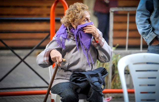 Grupo de riesgo. Una adulta mayor días atrás sentada esperando para cobrar la jubilación.