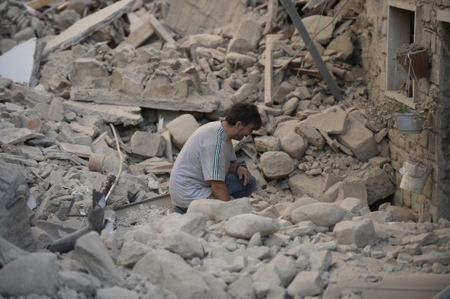 Un hombre se lamenta entre los restos de su casa en Amatrice.