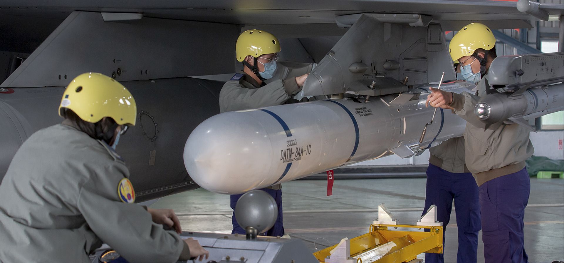 Personal de tierra coloca un misil en el ala de un avión de combate F-16 en la base de la Fuerza Aérea durante una visita de la presidenta taiwanesa Tsai Ing-wen a una base militar en Chiayi, suroeste de Taiwán. Viernes, 6 de enero de 2023. (Oficina presidencial de Taiwán vía AP)
