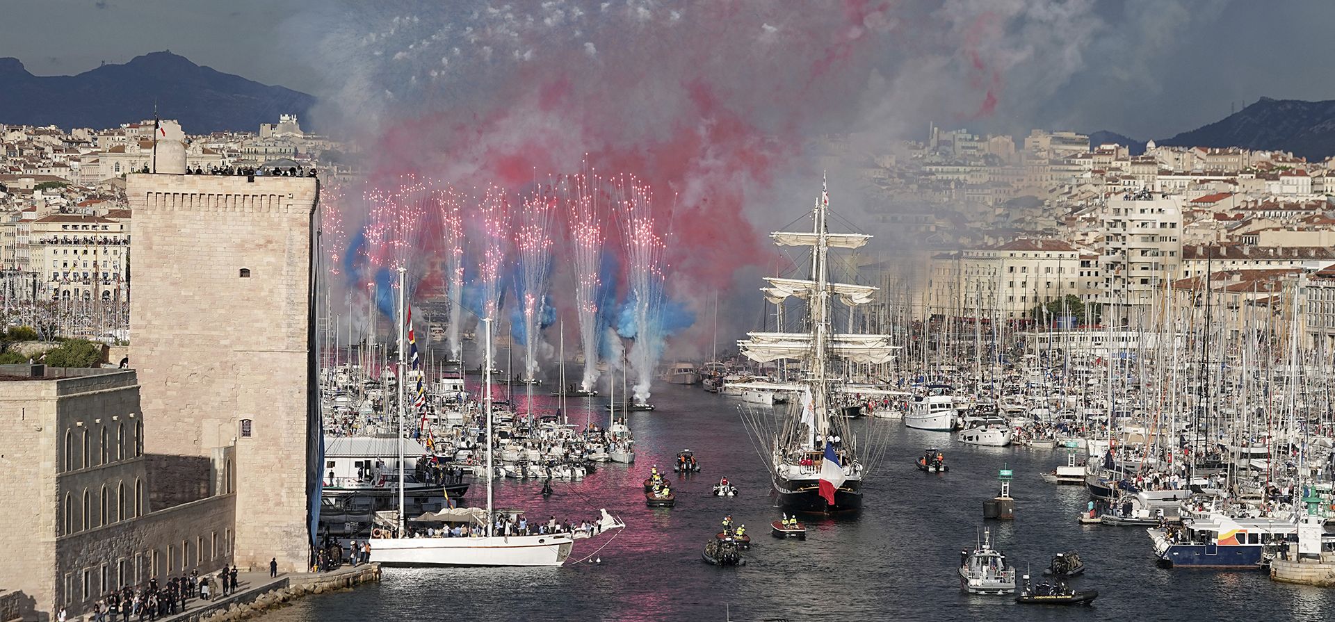 Fuegos artificiales iluminan el Belem, el velero de tres mástiles que trae la llama olímpica desde Grecia, ingresa al Puerto Viejo de Marsella, sur de Francia, el miércoles 8 de mayo de 2024. Después de salir de Marsella, se emprende una amplia ruta de relevo antes de la antorcha. Los Juegos Olímpicos de París 2024 se llevarán a cabo del 26 de julio al 11 de agosto de 2024. (Foto AP/Laurent Cipriani)