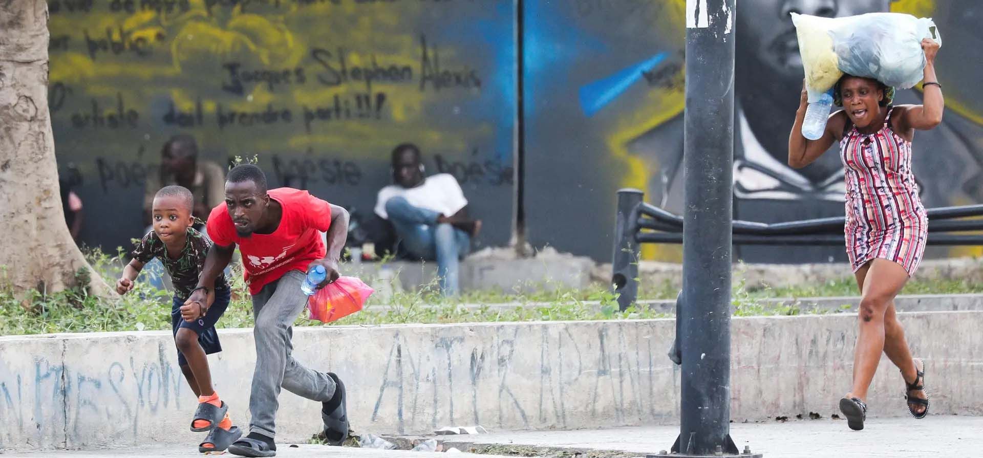 La gente se refugia de los disparos cerca del Palacio Nacional, Puerto Príncipe, Haití. Fotografía: Ralph Tedy Erol/Reuters La gente se refugia de los disparos cerca del Palacio Nacional, Puerto Príncipe, Haití. Fotografía: Ralph Tedy Erol/Reuters