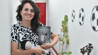 Ayelén Pujol, la autora, junto a su obra y el muñeco del Diego.