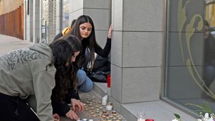 Adolescentes rinden homenaje en el altar levantado frente al edificio.