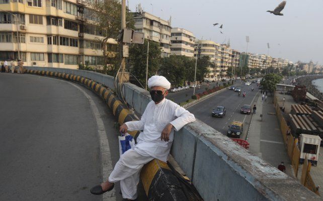Un hombre espera un taxi en un puente de Mumbai, India. Los casos de COVID-19 están aumentando en algunas partes de la India después de meses de una disminución constante en todo el país.