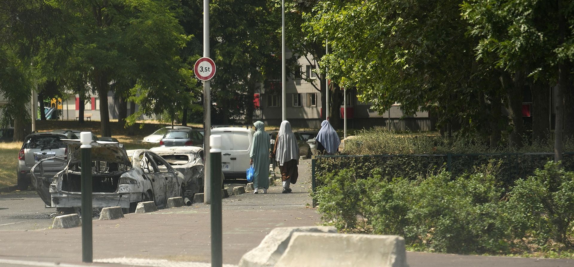 Residentes pasan junto a autos carbonizados en Nanterre, en las afueras de París. El gobierno anunció una mayor presencia policial en París y otras grandes ciudades y pidió calma después de que estallara la violencia dispersa por la muerte de un repartidor de 17 años que fue asesinado a tiros el martes 27 de junio de 2023 durante un control policial. (Foto AP/Lewis Joly) Residentes pasan junto a autos carbonizados en Nanterre, en las afueras de París. El gobierno anunció una mayor presencia policial en París y otras grandes ciudades y pidió calma después de que estallara la violencia dispersa por la muerte de un repartidor de 17 años que fue asesinado a tiros el martes 27 de junio de 2023 durante un control policial. (Foto AP/Lewis Joly)