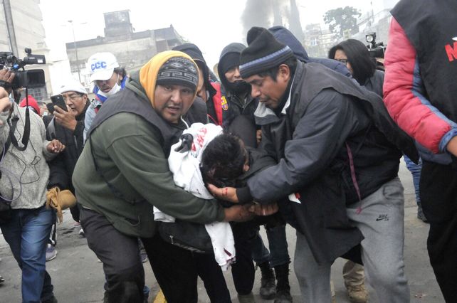Maniestantes llevan en brazos a un herido en medio de la represión policial desatada en Jujuy.