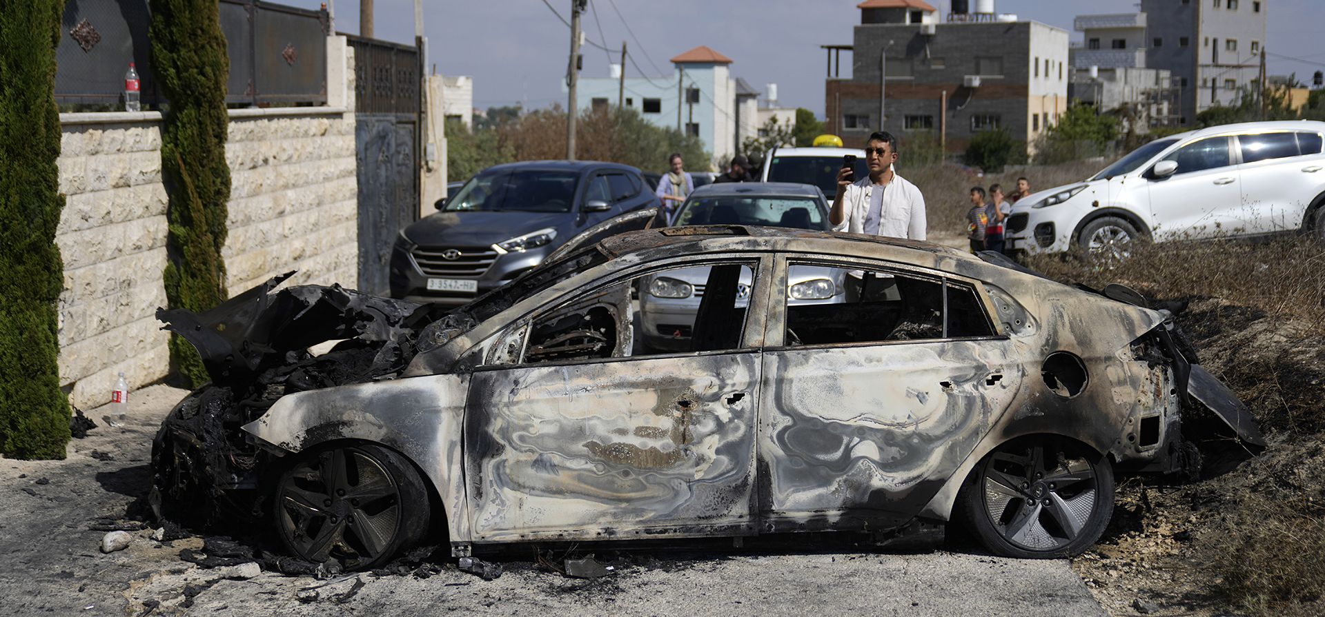 Un palestino filma un vehículo incendiado, visto la mañana después de un ataque perpetrado por colonos israelíes en la aldea cisjordana de Jit, el viernes 16 de agosto de 2024. (Foto AP/Nasser Nasser) Un palestino filma un vehículo incendiado, visto la mañana después de un ataque perpetrado por colonos israelíes en la aldea cisjordana de Jit, el viernes 16 de agosto de 2024. (Foto AP/Nasser Nasser)