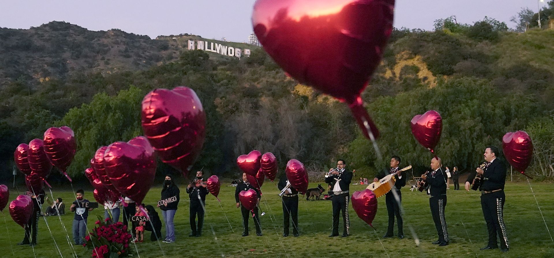 Una banda de mariachis mexicanos rodeada de globos en forma de corazón espera la llegada de la ceremonia de propuesta de boda de una pareja en el parque Lake Hollywood en Los Ángeles, el día de San Valentín. Foto: Archivo