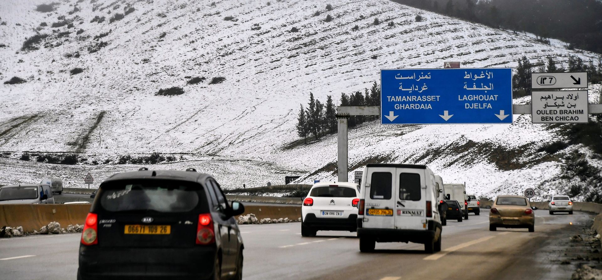 Autos pasan junto a montañas nevadas cerca de Ben Chicao, a casi 100 kilómetros (62 millas) al sur de Argel, el jueves 8 de enero de 2026 en París. (Foto AP/Fateh Guidoum)