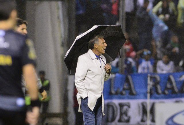 Abrió el paraguas. Russo observó el partido protegido de la lluvia en Salta.
