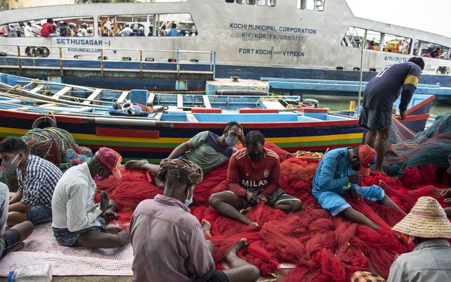 Pescadores reparan sus redes en Kochi