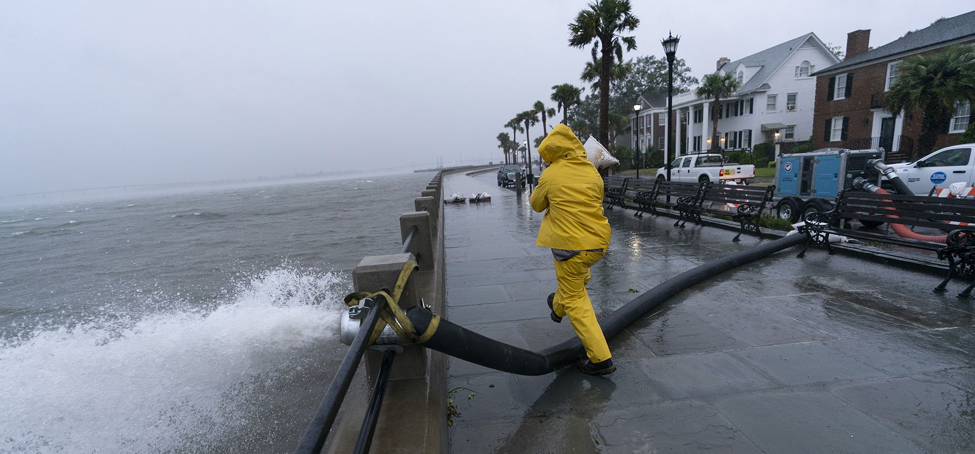 Un trabajador mueve un saco de arena después de que se colocara una bomba para extraer agua de la batería mientras se sienten los efectos del huracán Ian, el viernes 30 de septiembre de 2022, en Charleston, Carolina del Sur.