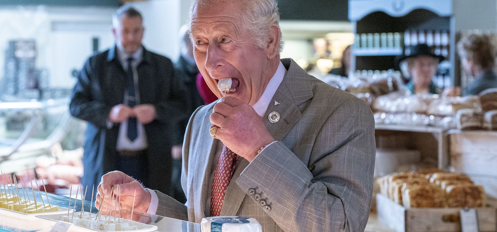 El príncipe Carlos de Gran Bretaña prueba un trozo de queso durante una visita a Tebay Services para conmemorar su 50ª aniversario, en Cumbria, Inglaterra, el miércoles 6 de abril de 2022.