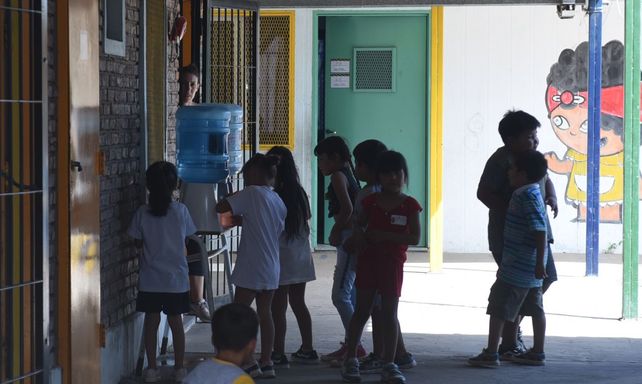 Ante las altas temperaturas y la poca agua en el barrio, en la Escuela Nº 1380 de zona sudoeste los nenes y nenas sacian la sed con bidones de agua.