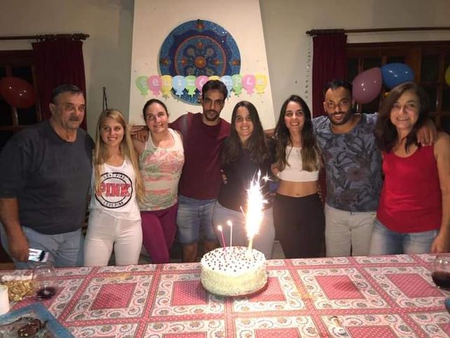 Los padres en las puntas y los sextillizos en torno a la torta de cumpleaños