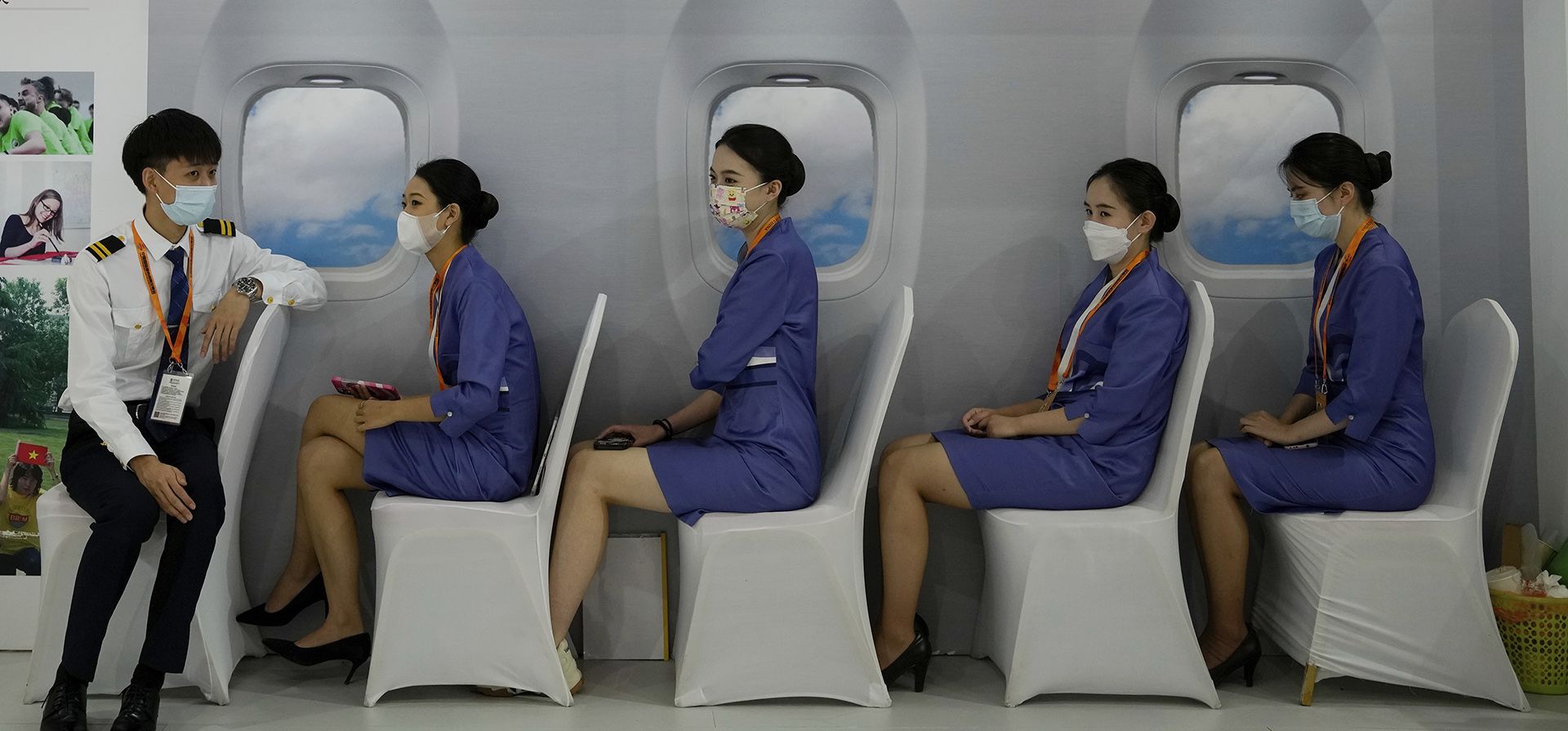 Trabajadores vestidos como miembros de la tripulación de cabina conversan entre sí en un stand decorado como una cabina de vuelo en el sector de servicios educativos para la Feria Internacional de Comercio de Servicios de China (CIFTIS) en el recinto de Shougang en Beijing, el jueves 1 de septiembre de 2022.