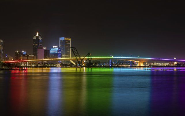 Foto proporcionada por la Autoridad de Transporte de Jacksonville, el Puente Acosta está iluminado con luces de arco iris en honor al Mes del Orgullo, en el centro de Jacksonville, Florida.