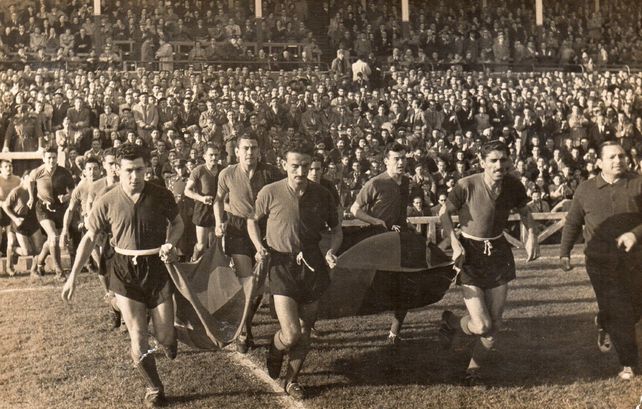 Los rojinegros portan banderas al entrar al estadio de La Coruña.