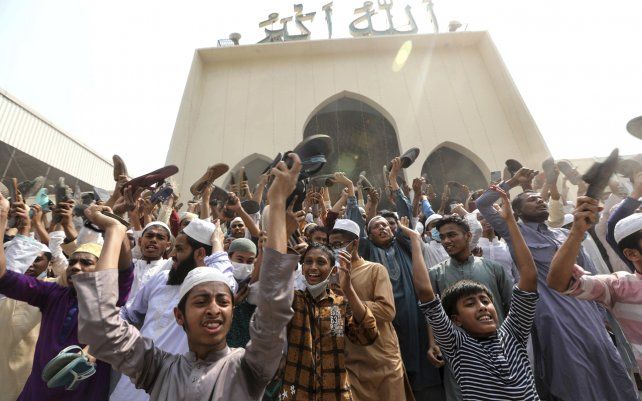 Un grupo de manifestantes grita consignas y agita zapatos después de las oraciones del viernes en la mezquita Baitul Mokarram en Dhaka, Bangladesh.