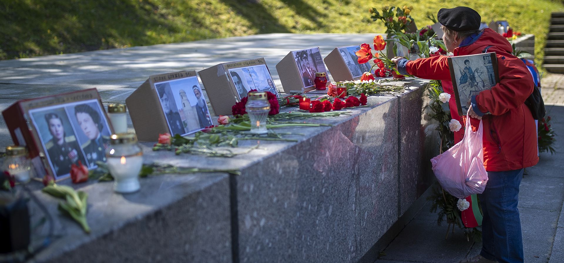 Una mujer deposita flores durante la conmemoración del 78º aniversario del fin de la Segunda Guerra Mundial en el cementerio de Antakalnis en Vilnius, Lituania, el martes 9 de mayo de 2023. (Foto AP/Mindaugas Kulbis)