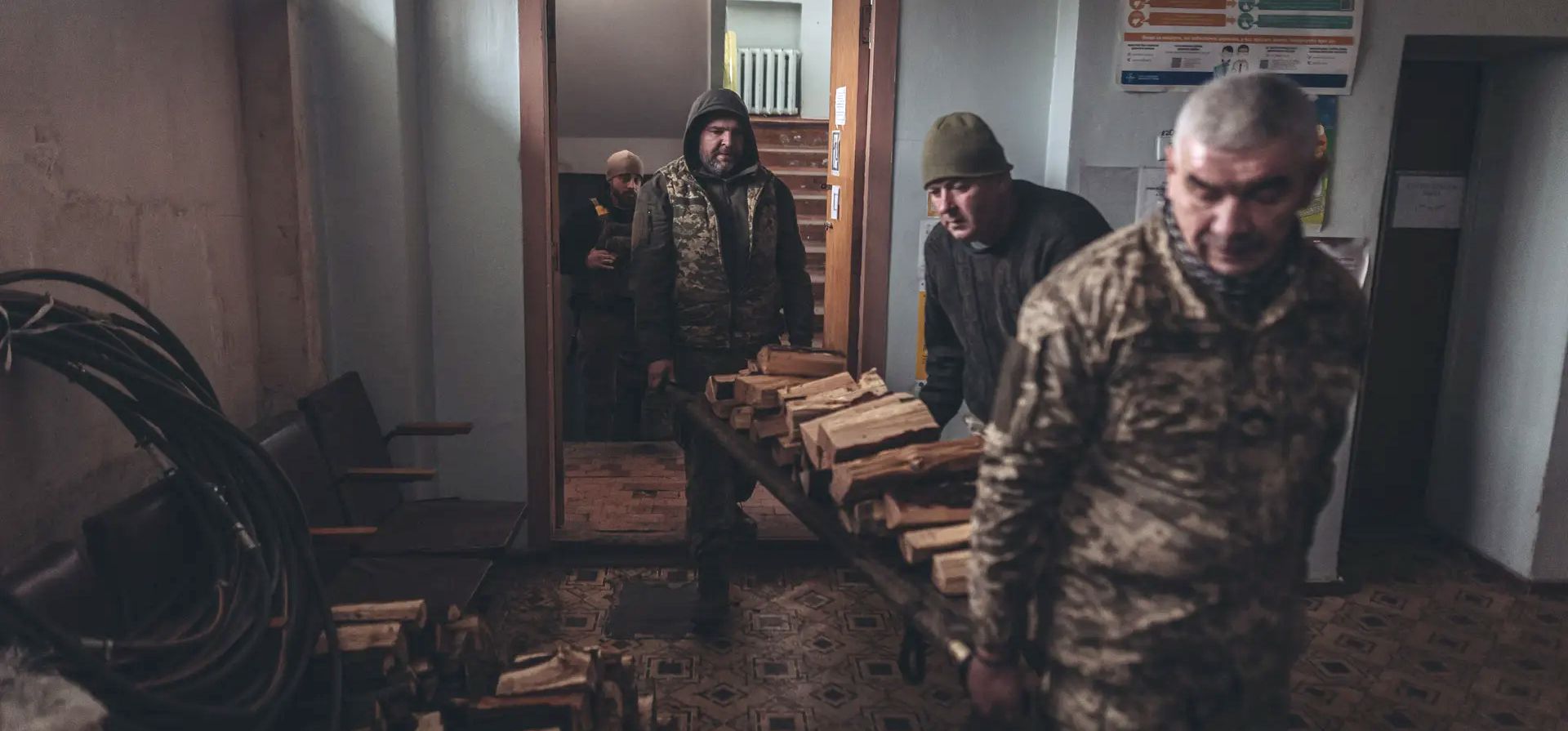 Donbas, Ucrania. Soldados ucranianos llevan leña en un hospital de Donbás. Fotografía: Agencia Anadolu/Getty