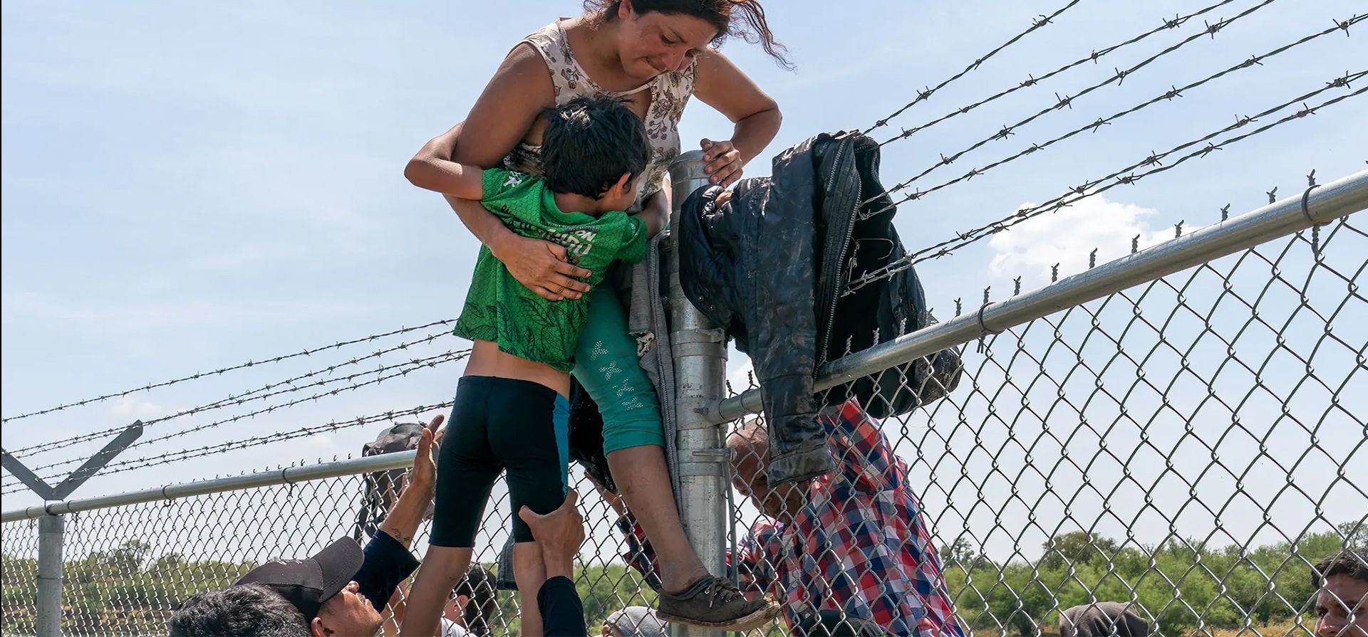 Texas, Estados Unidos. Una madre ayuda a su hijo a cruzar la cerca de alambre de púas después de cruzar a los Estados Unidos desde México. Fotografía: Suzanne Cordeiro/AFP/Getty Images Texas, Estados Unidos. Una madre ayuda a su hijo a cruzar la cerca de alambre de púas después de cruzar a los Estados Unidos desde México. Fotografía: Suzanne Cordeiro/AFP/Getty Images