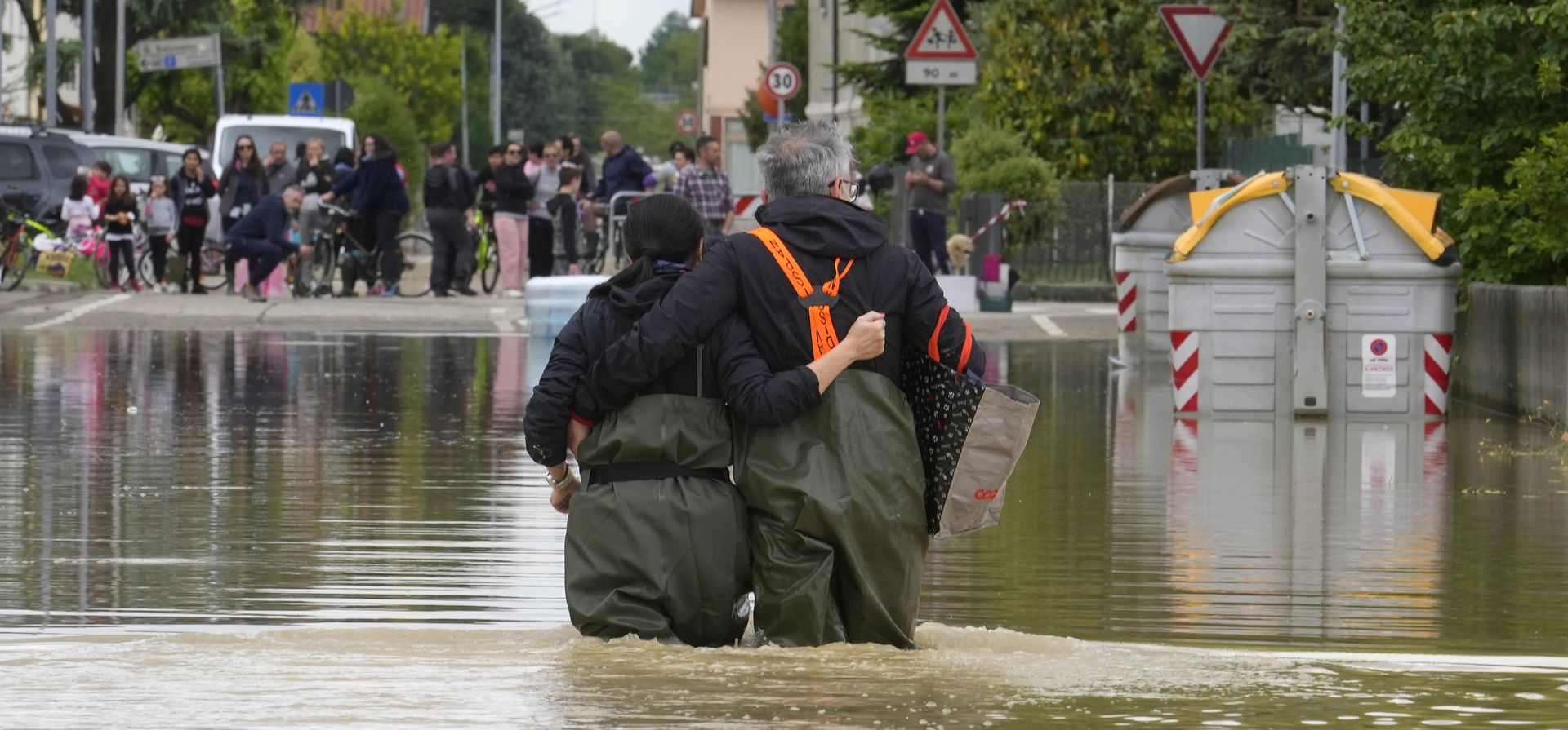 Una pareja camina en una carretera inundada de Lugo, Italia, el jueves 18 de mayo de 2023. Lluvias excepcionales el miércoles en una región del norte de Italia afectada por la sequía desbordaron los ríos, obligando a la evacuación de miles de personas. (Foto AP/Luca Bruno)