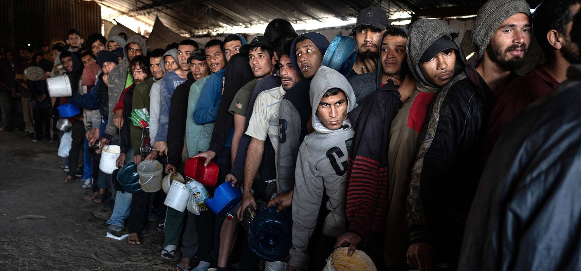 Reclusos hacen fila para recibir una comida proporcionada por la cárcel, conocida como 