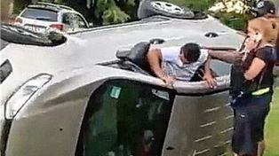 El Pulga Rodríguez sale del auto siniestrado luego de auxiliar a la mujer que conducía.