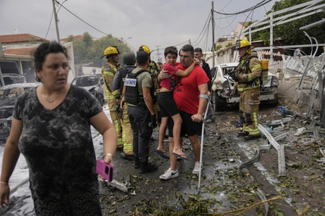 Israelíes evacúan su casa destrozada por un misil palestino en la ciudad de Ashkelón este lunes.