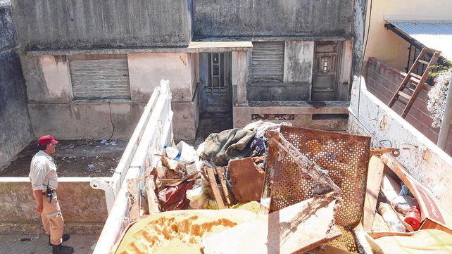 Nauseabundo. Obreros ayudan a la salida de camiones con residuos.