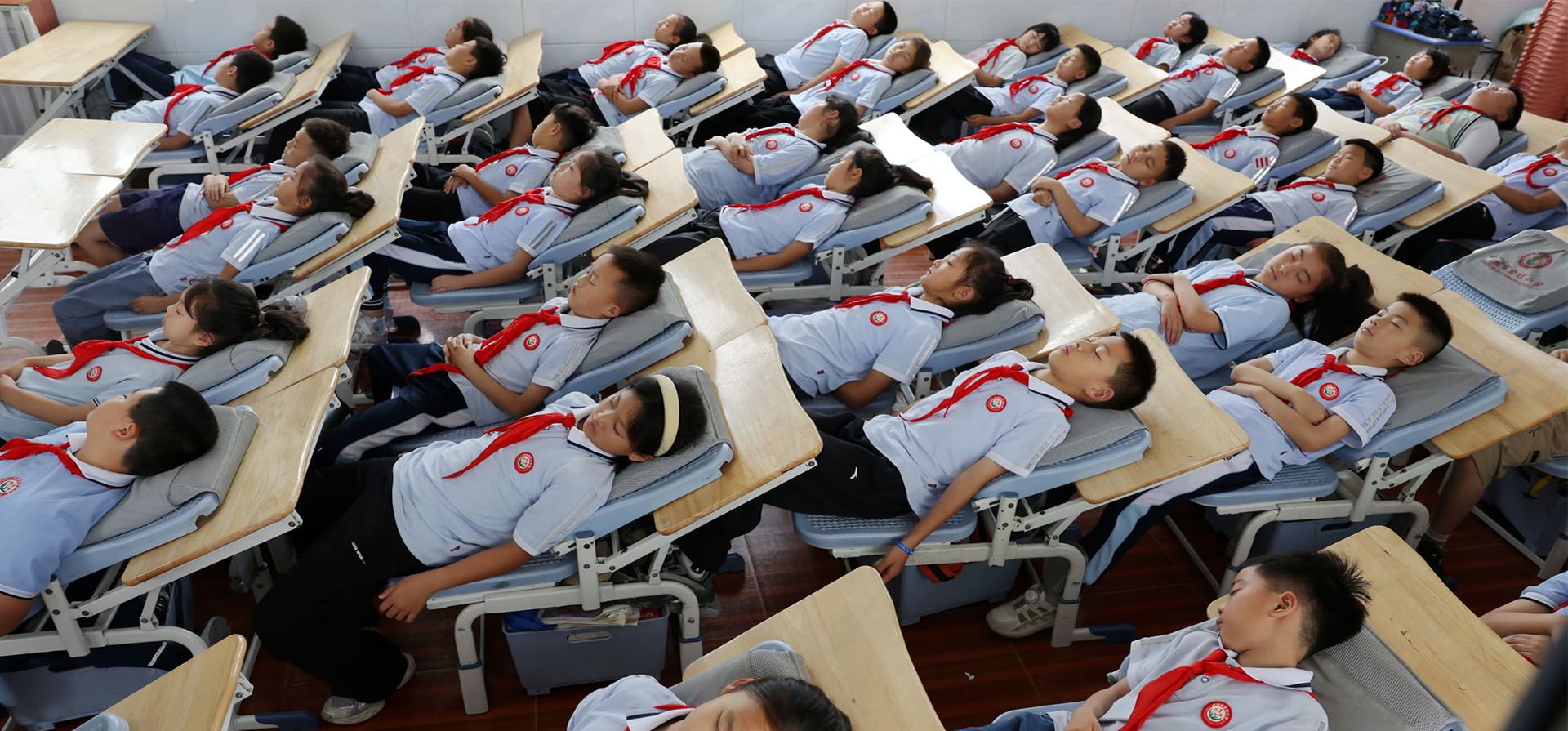 Alumnos de una escuela primaria se recuestan para tomar una siesta. Escuelas locales han incorporado conjuntos de pupitres y sillas plegables especialmente diseñados para descansar, Enshi, provincia de Hubei, China. Fotografía: VCG/Getty Images Alumnos de una escuela primaria se recuestan para tomar una siesta. Escuelas locales han incorporado conjuntos de pupitres y sillas plegables especialmente diseñados para descansar, Enshi, provincia de Hubei, China. Fotografía: VCG/Getty Images
