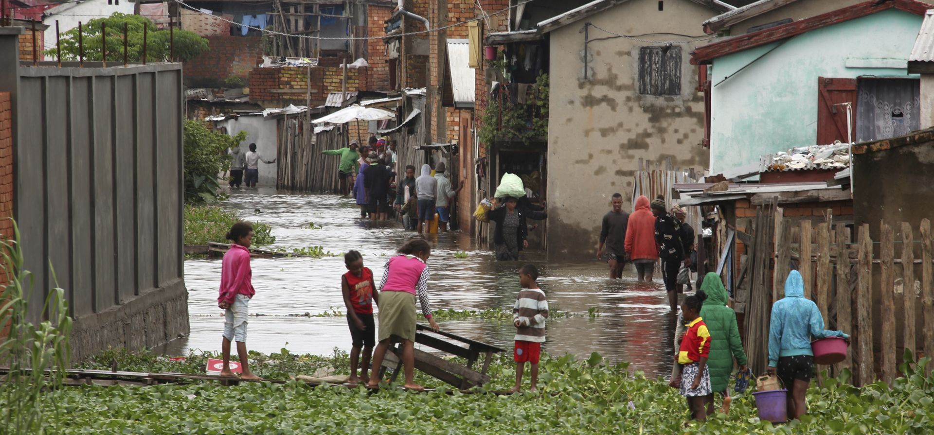 Residentes caminan a través del agua de la inundación alrededor de sus casas después de las fuertes lluvias en Antananarivo, el miércoles 19 de enero de 2022. Las autoridades en Madagascar dicen que las fuertes lluvias han inundado partes de la ciudad capital, Antananarivo, muriendo 10 personas y dejando a más de 12,000 sin hogar.