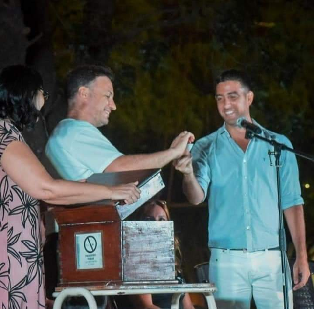 El senador de General López, Lisandro Enrico (UCR), extrae un cupón que benefició a una familia. A su izquierda, el mandatario radical, Benjamín Gianetti.