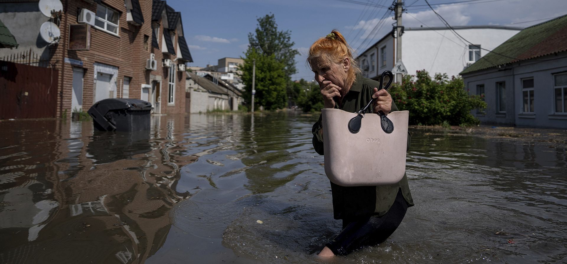 Una residente local se abre paso a través de una carretera inundada después de que las tropas rusas volaran la represa Kakhovka durante la noche, en Kherson, Ucrania, el martes 6 de junio de 2023. (Foto AP/Evgeniy Maloletka) Una residente local se abre paso a través de una carretera inundada después de que las tropas rusas volaran la represa Kakhovka durante la noche, en Kherson, Ucrania, el martes 6 de junio de 2023. (Foto AP/Evgeniy Maloletka)